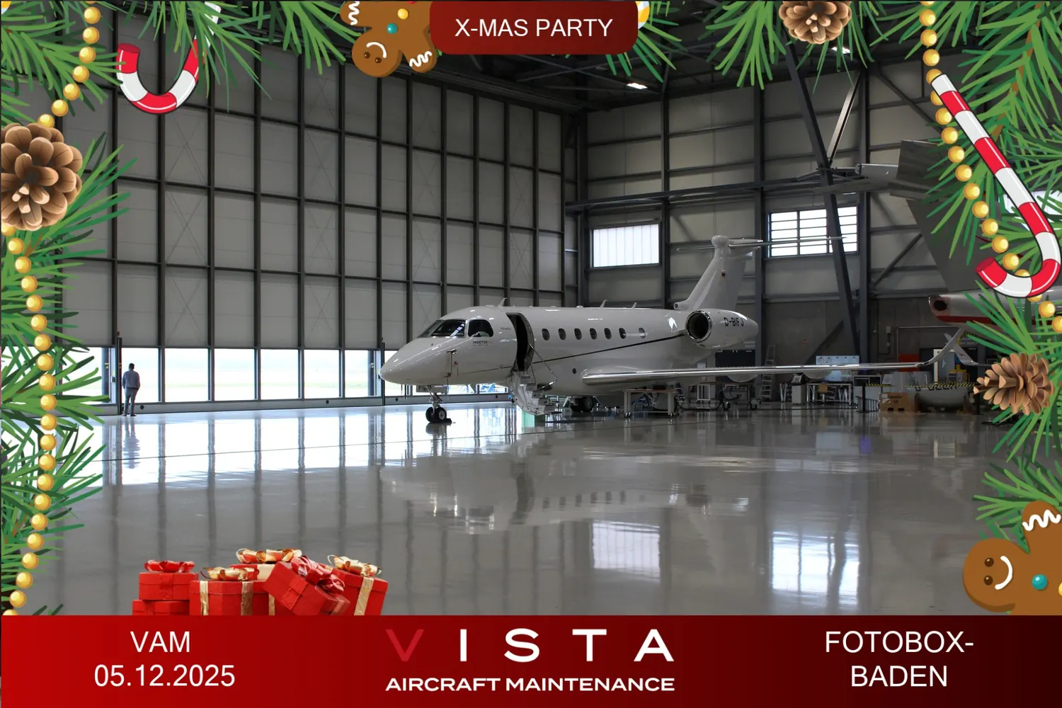 Print mit Weihnachts-Overlay: Firmenjet im Hangar, umrahmt von Tannenzweigen, mit Firmenlogo und Datum